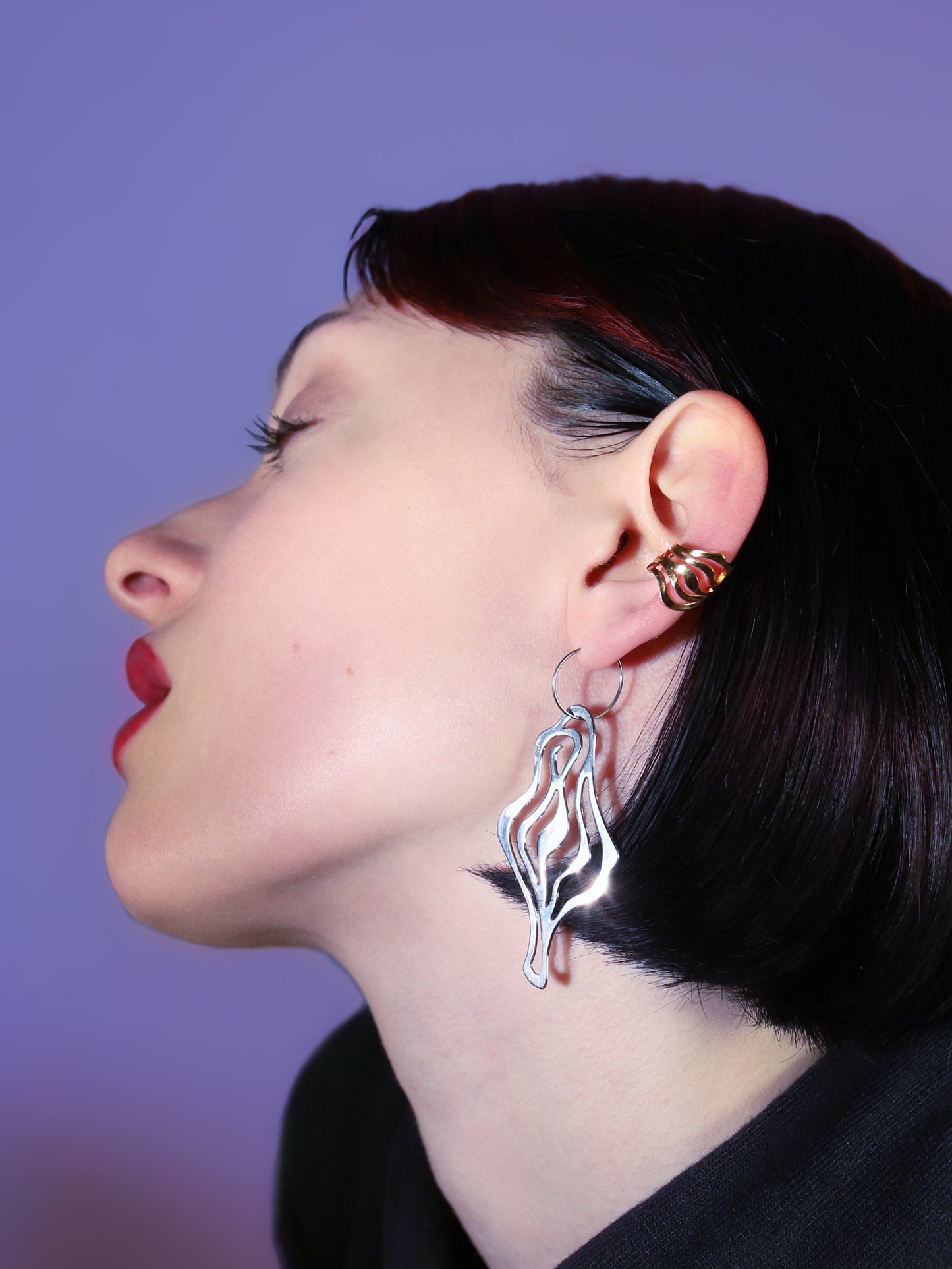 Mini VULVA ear clasp – no piercing needed! This statement piece curls around your ear for a unique look. One size, galvanized brass. Made in Italy.